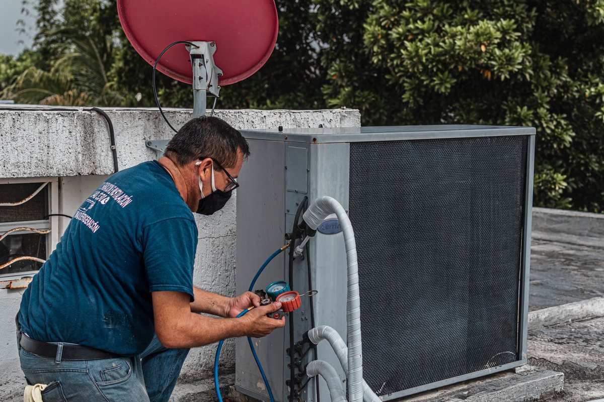 Technician diagnosing an air conditioner unit